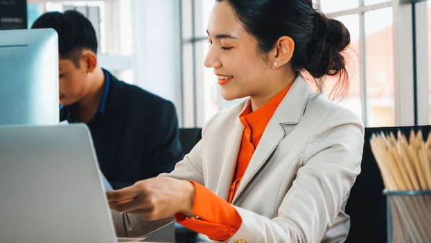 Two business people talk project strategy at office meeting room. Businessman discuss project planning with colleague at modern workplace while having conversation and advice on financial report. Jivy