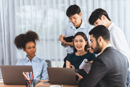 Happy diverse business people work together, discussing in corporate office. Professional and diversity teamwork discuss business plan on desk with laptop. Modern multicultural office worker. Concord