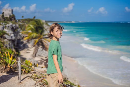 Boy tourist enjoying the view Pre-Columbian Mayan walled city of Tulum, Quintana Roo, Mexico, North America, Tulum, Mexico. El Castillo - castle the Mayan city of Tulum main temple.