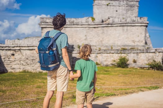 Father and son tourists enjoying the view Pre-Columbian Mayan walled city of Tulum, Quintana Roo, Mexico, North America, Tulum, Mexico. El Castillo - castle the Mayan city of Tulum main temple.