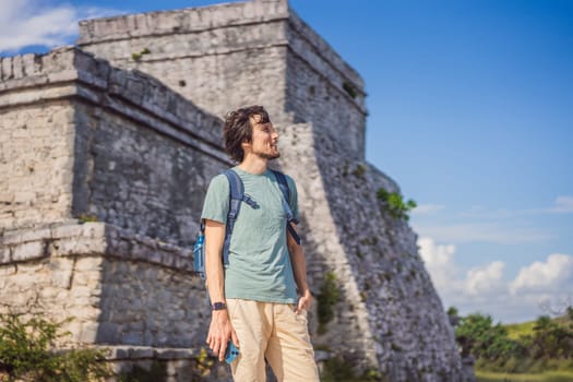 Male tourist enjoying the view Pre-Columbian Mayan walled city of Tulum, Quintana Roo, Mexico, North America, Tulum, Mexico. El Castillo - castle the Mayan city of Tulum main temple.