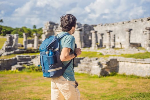 Male tourist enjoying the view Pre-Columbian Mayan walled city of Tulum, Quintana Roo, Mexico, North America, Tulum, Mexico. El Castillo - castle the Mayan city of Tulum main temple.