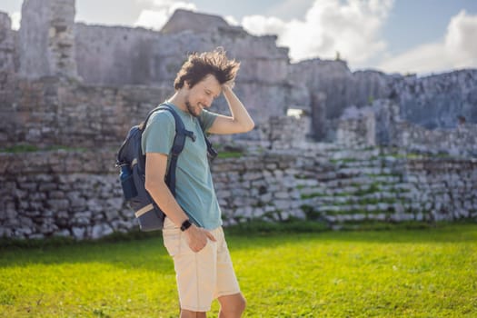 Male tourist enjoying the view Pre-Columbian Mayan walled city of Tulum, Quintana Roo, Mexico, North America, Tulum, Mexico. El Castillo - castle the Mayan city of Tulum main temple.