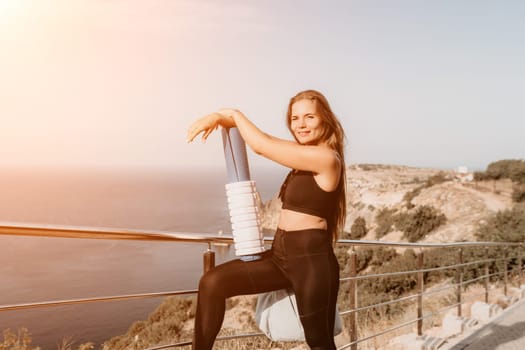 Fitness woman sea. Outdoor workout on yoga mat in park near to ocean beach. Female fitness pilates yoga routine concept. Healthy lifestyle. Happy fit woman exercising with rubber band in park.