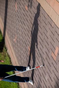 A faceless blind woman walks down the street with a cane