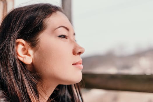 Happy young smiling woman with freckles outdoors portrait. Soft sunny colors. Outdoor close-up portrait of a young brunette woman and looking to the camera, posing against nature background.