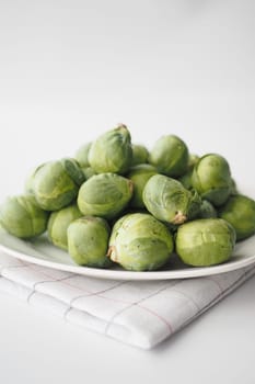 Fresh brussels sprouts in a box on a white background.