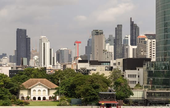 Bangkok, Thailand - 28 Sep, 2024 - Exterior view of The old customs house Or Old bang rak fire station building with Skyscrapers background at Bangkok city. Architectural View of Old and New Buildings in Contrasting Classical and Modern Designs, Space for text, Selective focus.
