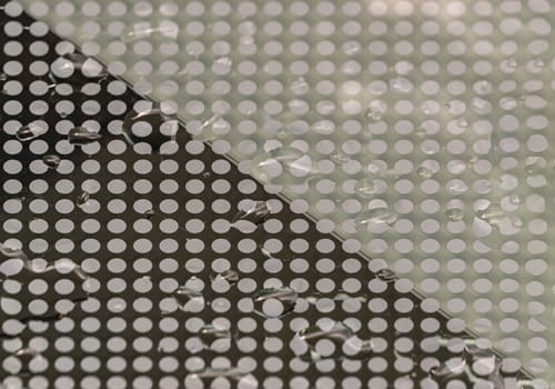 Detail of Water droplets caused by rain perched on surface of the Glass. Rain water drops on a Glass floor, Natural Pattern of dew drops or raindrops on galss background for wallpaper, Poster and Space for text, Selective focus.