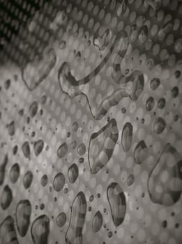 Rain water drops on a Glass floor. Detail of Water droplets caused by rain perched on surface of the Glass. Natural Pattern of dew drops or raindrops on galss background for wallpaper, Poster and Copy space, Selective focus.