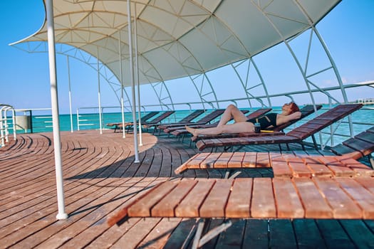 Beach vacation on sea resort, woman in swimwear lying in sun bed chair