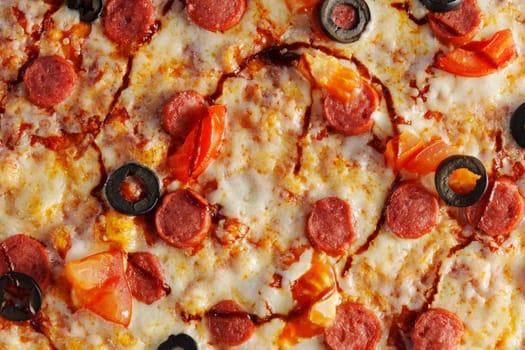 A delicious pepperoni pizza topped with olives and tomatoes served warm on a wooden board ready for sharing at a cozy gathering