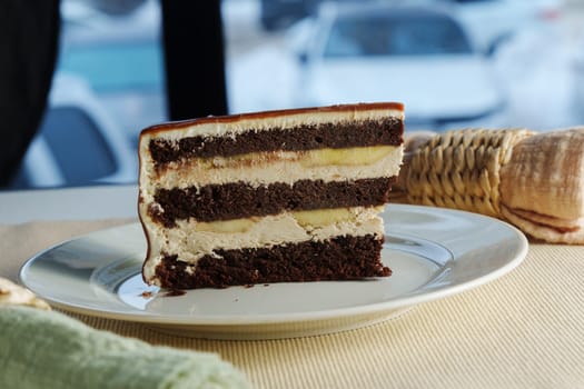 Decadent chocolate layer cake with creamy frosting showcased on a pristine plate against a dark backdrop
