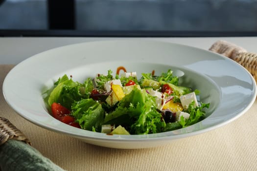 colorful plate filled with crisp lettuce, juicy cherry tomatoes, crunchy cucumbers, and creamy feta, harmoniously drizzled with balsamic dressing
