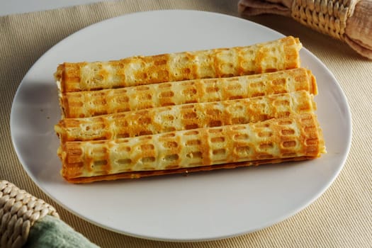 Delight in the sight of freshly made, golden waffles arranged neatly on a round plate