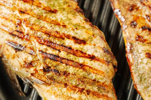 Grilled salmon fillets sizzle and sear on the grill, releasing mouthwatering aromas.