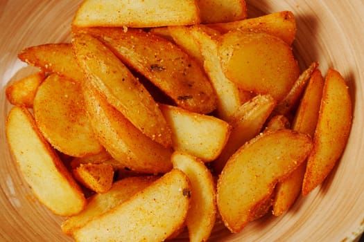 Crispy seasoned potato wedges served in a rustic bowl, a delightful snack perfect for sharing during a cozy gathering