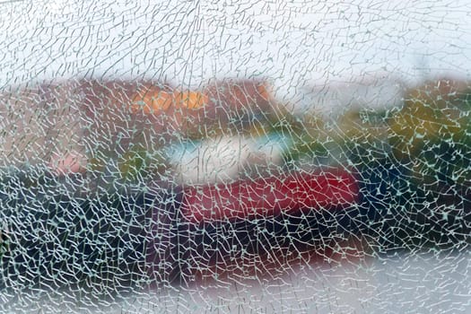 A close-up view of fragmented glass creating an abstract texture while hinting at a vibrant background in the urban environment