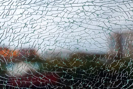 A close-up view of fragmented glass creating an abstract texture while hinting at a vibrant background in the urban environment