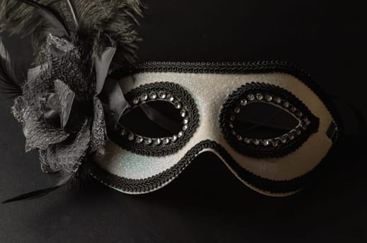Bangkok, Thailand - 17 Sep, 2024 - Beautiful mysterious venetian mask with feathers design on dark background, Light and Shadow, Space for text. Selective Focus.