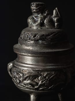 Bangkok, Thailand - 17 Sep, 2024 - Sculpture engraved decorate on small silver ancient incense burner on dark background. Antiques, Light and Shadow, Space for text, Selective focus.