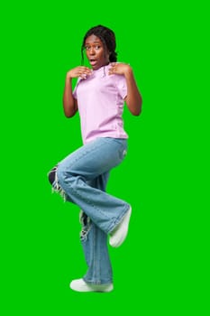 Surprised young woman against a vibrant green background expressing astonishment or shock close up