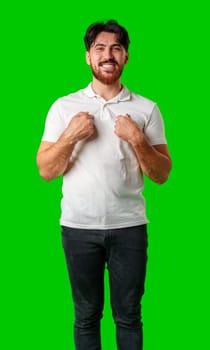 Smiling man in a white polo shirt standing confidently against a bright green background close up