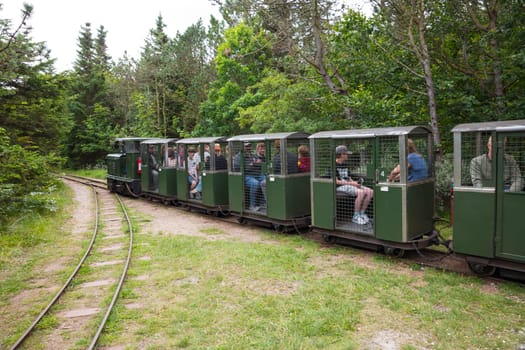 hansholm,denmark,18-08-2024:people enjoy a ride on the old ammunition train in hansholm denmakr, the ammunition used in the 38 cm guns was too heavy to be simply carted around on a handcart.