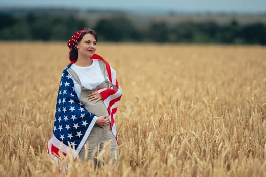Pregnant Patriot Woman Standing With American National Flag In Rural Wheat Field landscape. Symbol of democracy, independence, USA, 4th July celebration, US banner, election, America, labor