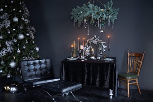 New Year stylish interior in dark style, New Year tree with New Year toys and decorated table in dark style