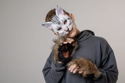 portrait of a teenager quadrobics in a cat mask on a white background, quadrobika subculture imitation of animal actions