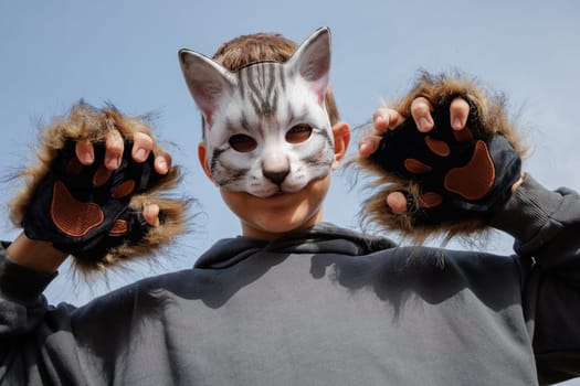 quadrobics teenager in cat mask sits on all fours in park, quadrobika subculture imitation of animal actions