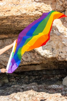woman, middle aged, outdoors waving pride flag, concept of libertat, equality.