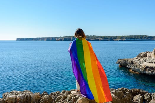 woman, middle aged, outdoors waving pride flag, concept of libertat, equality.