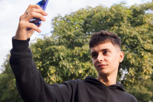 caucasian male teen smiling happy taking selfie photo with mobile phone, concept of youth lifestyle and technology of communication