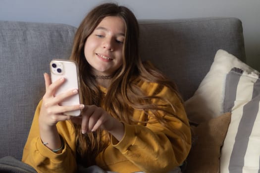 Girl relaxing on a sunny morning at home chatting with her friends.Free lifestyle concept. Moments of calm and happiness. Technology at home