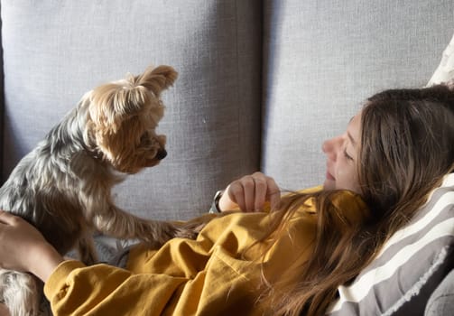 Teenager enjoying a cute moment with her puppy at home. Free lifestyle concept. Moments of calm and happiness. Puppy lovers.Children's relationship with pets