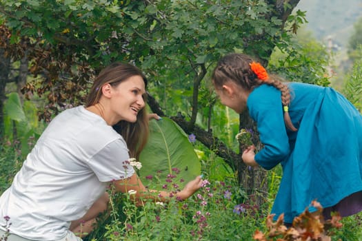 A heartwarming scene of a mother and daughter joyfully discovering flowers in a vibrant garden of greenery