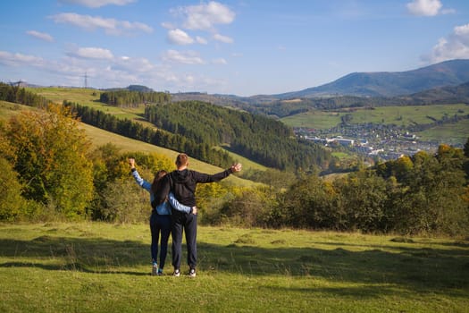 very beautiful panorama of the Carpathians in the autumn-a beautiful couple stands with their backs.