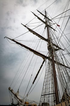 A magnificent view of towering ship masts extending into a gray, cloudy sky, capturing the essence of maritime adventure and nautical history.