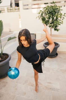 A poised individual demonstrates impressive balance and remarkable strength while skillfully using a blue exercise ball