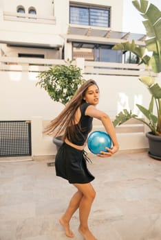 A young girl is joyfully enjoying a lively and fun moment with a colorful bowling ball in a stylish outdoor setting