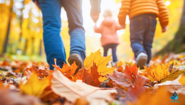 Family is enjoying a sunny autumn day by walking on fallen leaves in a forest