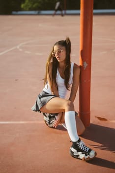 A trendy young woman strikes a stylish pose on a vibrant basketball court, embodying the urban vibe of youth