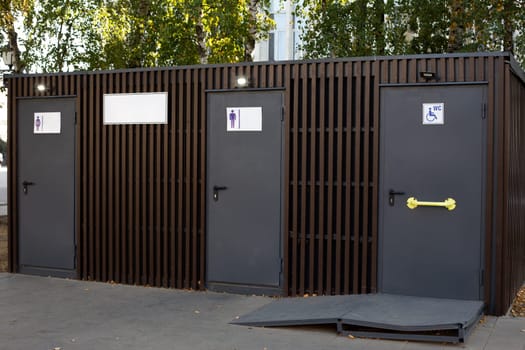 Modern public toilet on street, convenient wc for people with access for men, women and people with disabilities, accessible environment for disabled people with special ramp to toilet door
