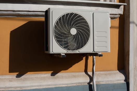 External air conditioner unit on building, close up photo of gray air conditioner on facade of house, changing and controlling temperature of house on hot day using equipment