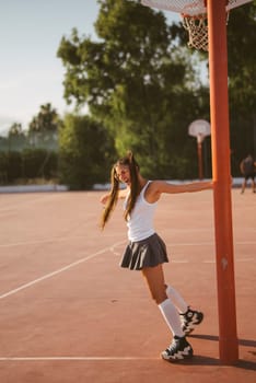 On a bright, sunny day, a young girl delights in roller skating at a nearby basketball court, enjoying every moment