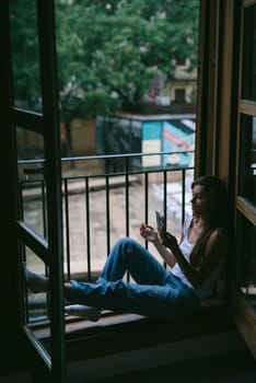 A serene scene of a person sitting by a window, enjoying a moment of leisure and connection with nature.