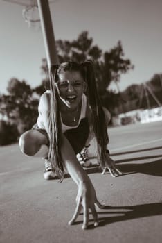 A striking black and white photograph captures a performer showcasing remarkable and dramatic movement outdoors