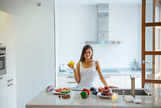 A woman skillfully preparing vibrant, healthy meals using fresh fruits in a stylish and modern kitchen setting